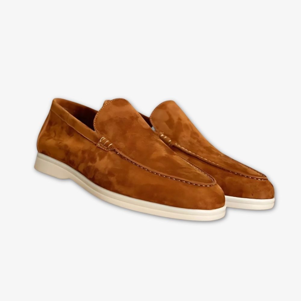 Mocassins Stefano en cuir véritable en version marron, posées sur leur boite à chaussures, sur fond gris.