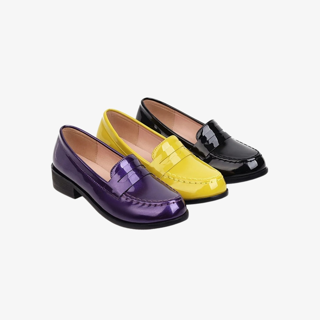Mocassins pour femme en cuir verni, disponibles en trois couleurs vibrantes : noir, jaune et violet. Ces chaussures élégantes et brillantes arborent un design classique avec une semelle basse, parfaites pour apporter une touche de style à une tenue décontractée ou chic.