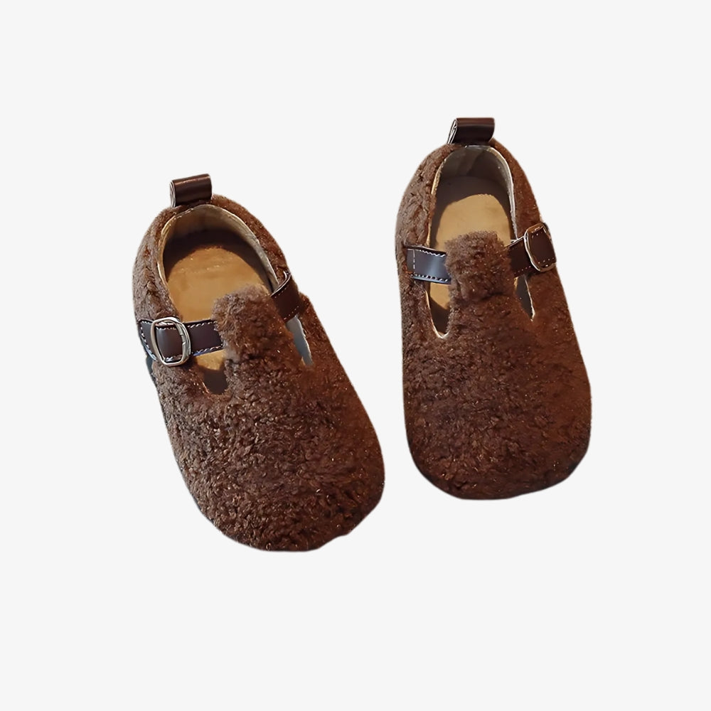 Mocassin en fausse fourrure pour fille sur fond gris clair.