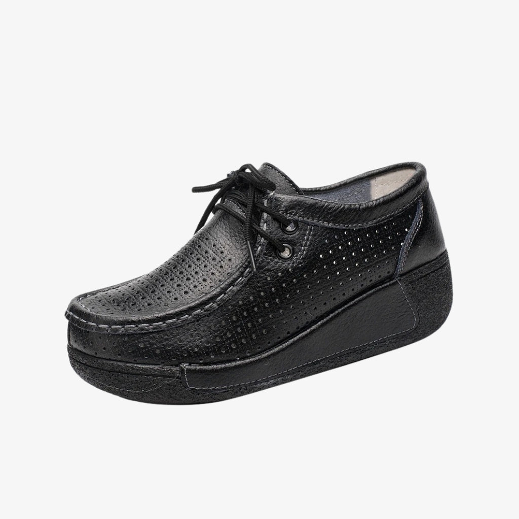 Mocassins pour femme en cuir noir, au design perforé pour une meilleure aération. Dotées de lacets pour un ajustement précis, ces chaussures élégantes sont équipées de semelles compensées noires offrant un bon maintien et un confort optimal tout au long de la journée.
