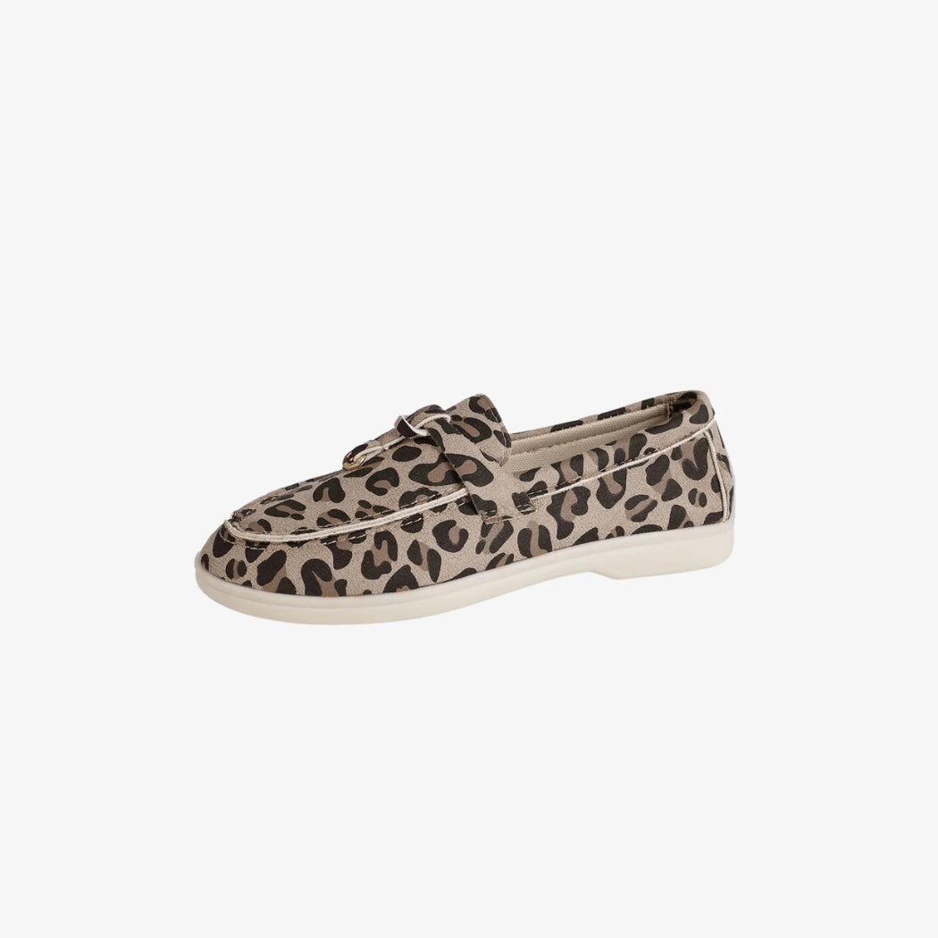 Mocassins pour femme en daim avec un motif léopard élégant. Ces chaussures légères et confortables sont dotées d'une semelle blanche discrète et d'une mariée décorative sur le dessus, parfaites pour un style décontracté et tendance.