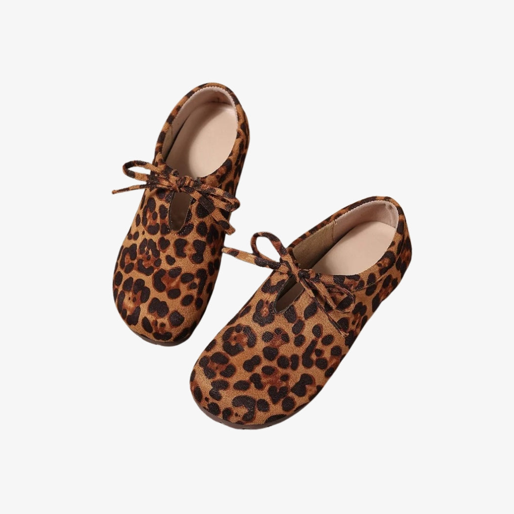 Mocassins pour femme en daim avec un motif léopard audacieux. Ces chaussures élégantes sont ornées d'un nœud délicat sur le dessus, ajoutant une touche féminine. Confortables et légères, elles sont idéales pour un style casual-chic.