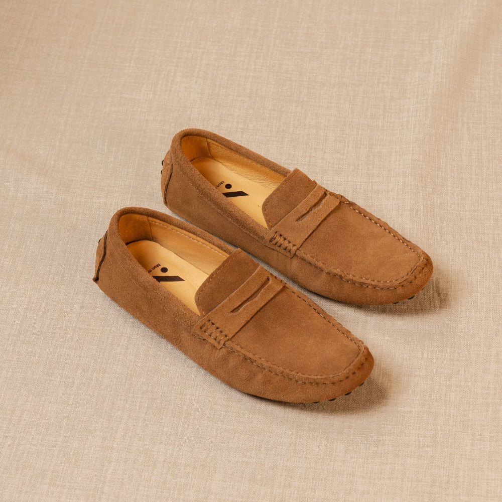 mocassin classico marron posé au sol sur un fond beige