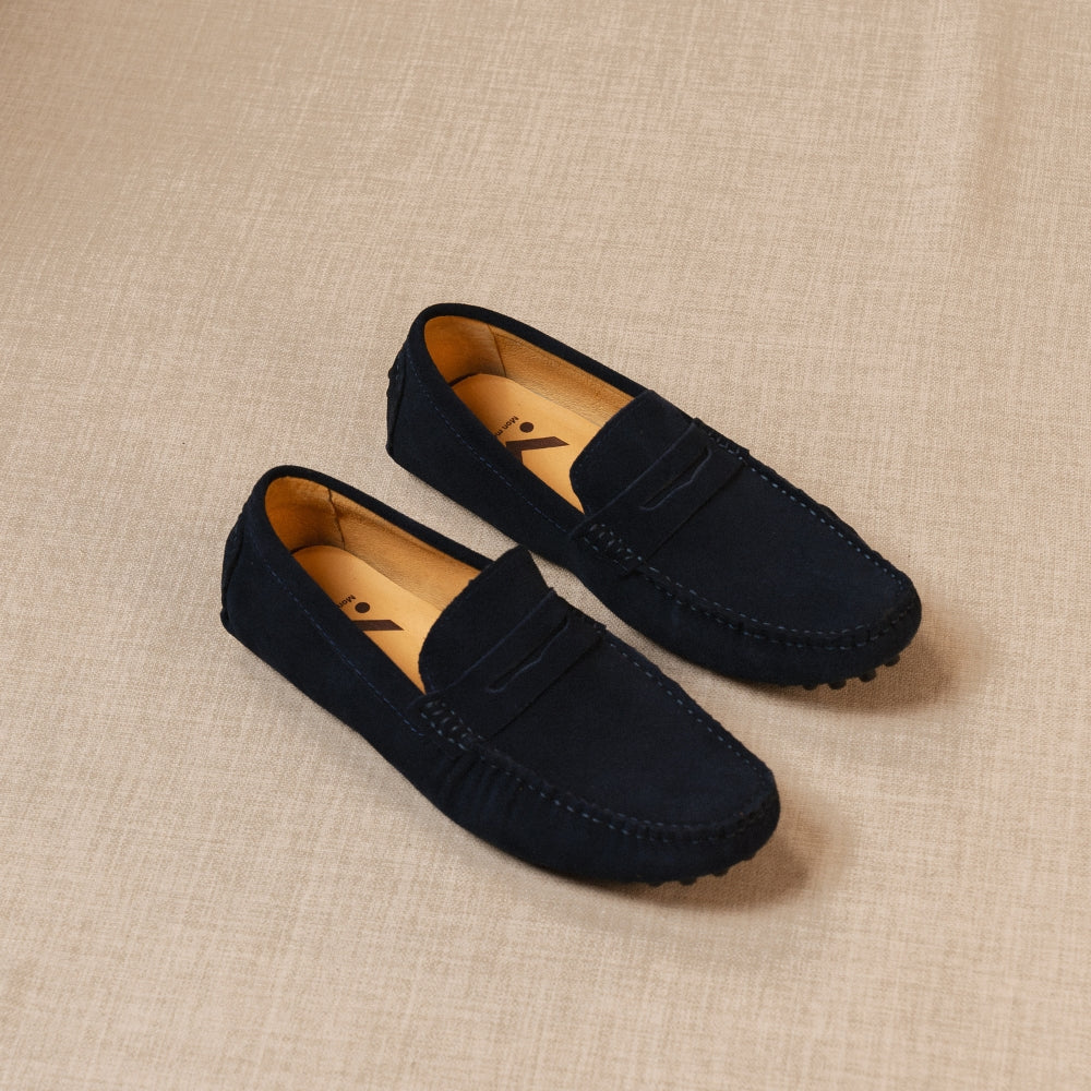mocassin classico bleu posé au sol sur un fond beige