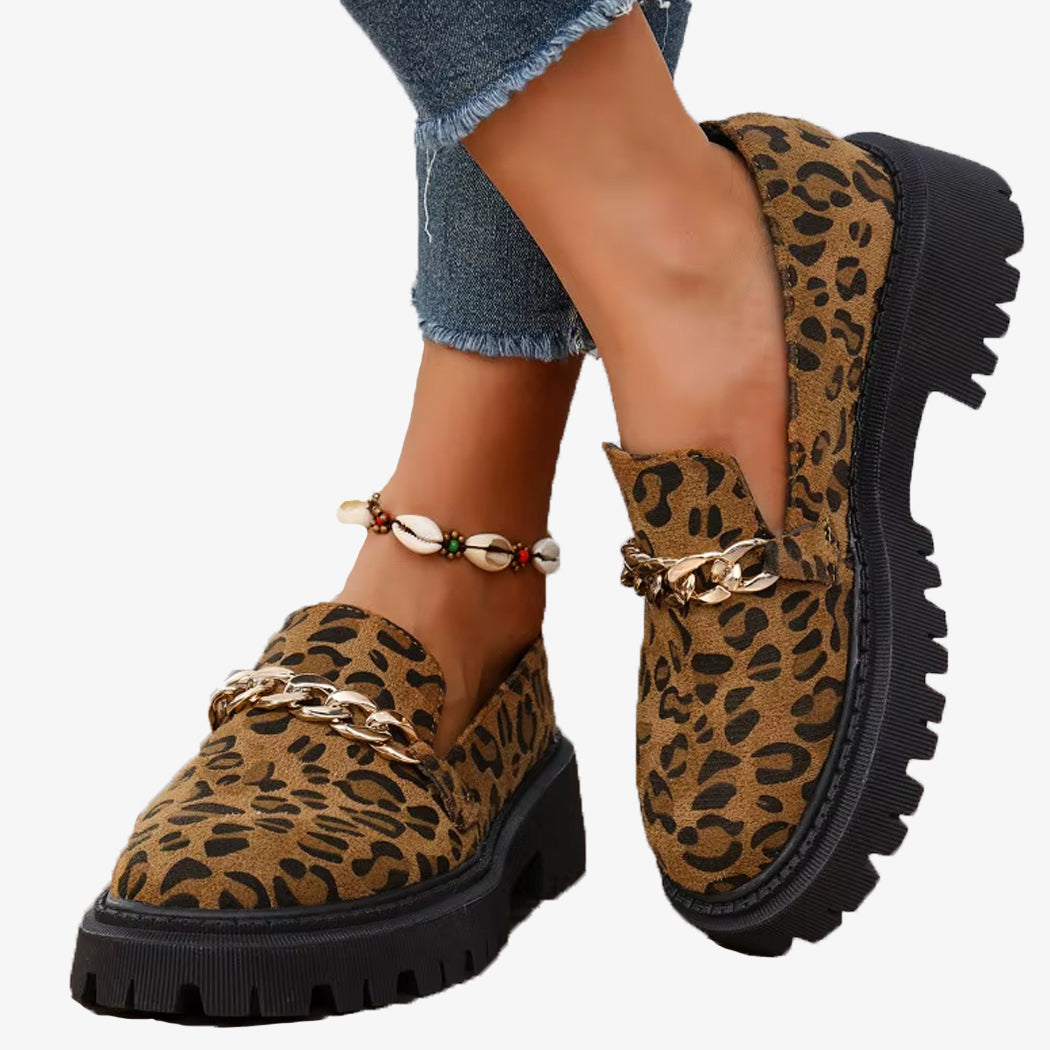 Paire de mocassins leopard en daim a plateforme avec une chaine, portees avec un jean et un bracelet de coquillage a la cheville