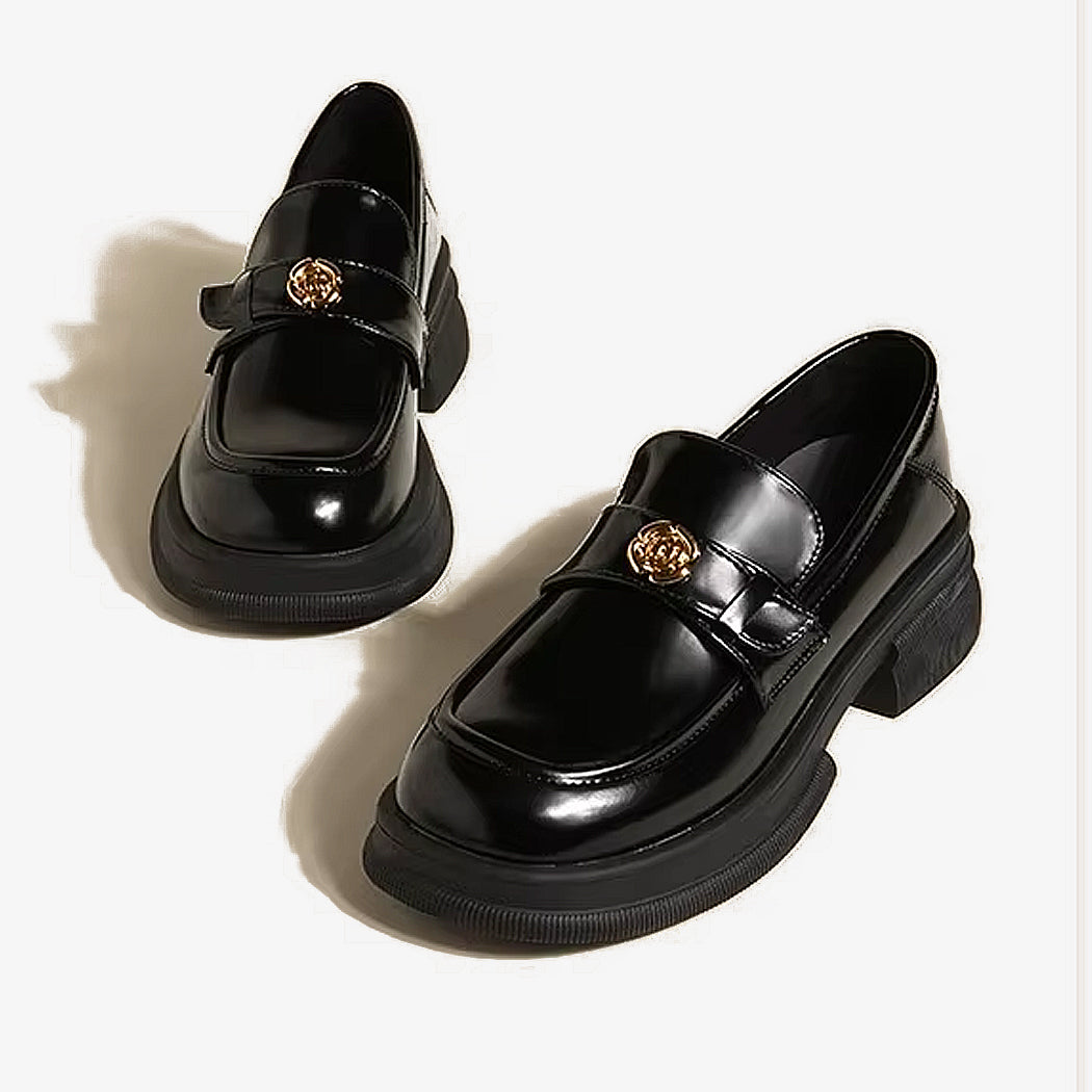 Paire de mocassins noirs a plateforme avec un détails de fleur metallique