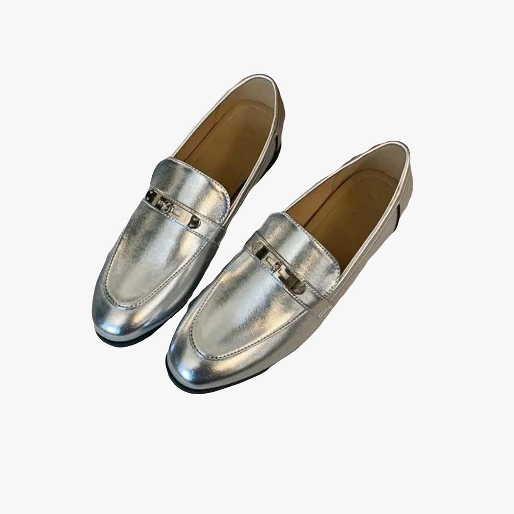 on voit sur un fond clair une paire de mocassins argentés à talons carrés pour femme
