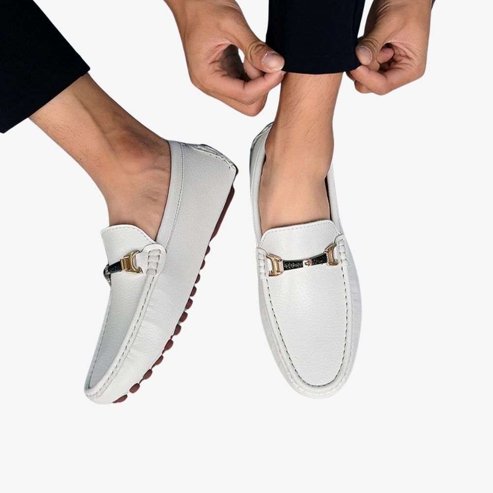 Paire de mocassins blancs en cuir pour homme, portées par un homme avec un pantalon noir