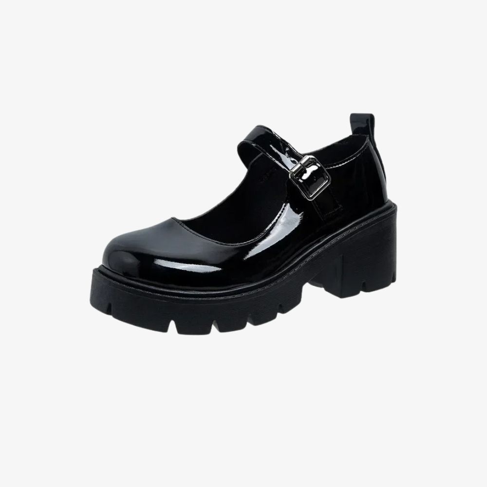 Un mocassin noir vernis avec des talons épais crantés et une bride sur le dessus.