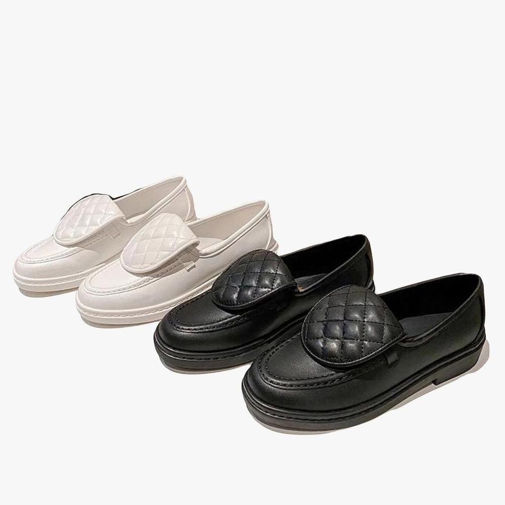 on voit deux paires de mocassins avec dessus matelassé et talons carrés pour femme une paire blanche et une paire noire côte à côte