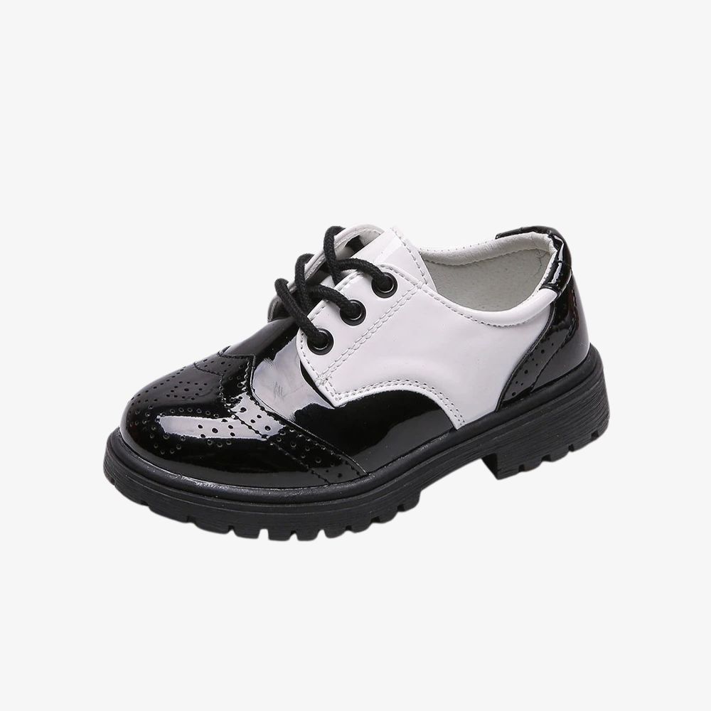 Un mocassin fermé pour enfant, noir brillant avec une partie blanche