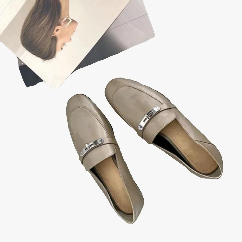on voit sur un sol gris clair des mocassins gris légers à talons carrés en cuir véritable pour femme