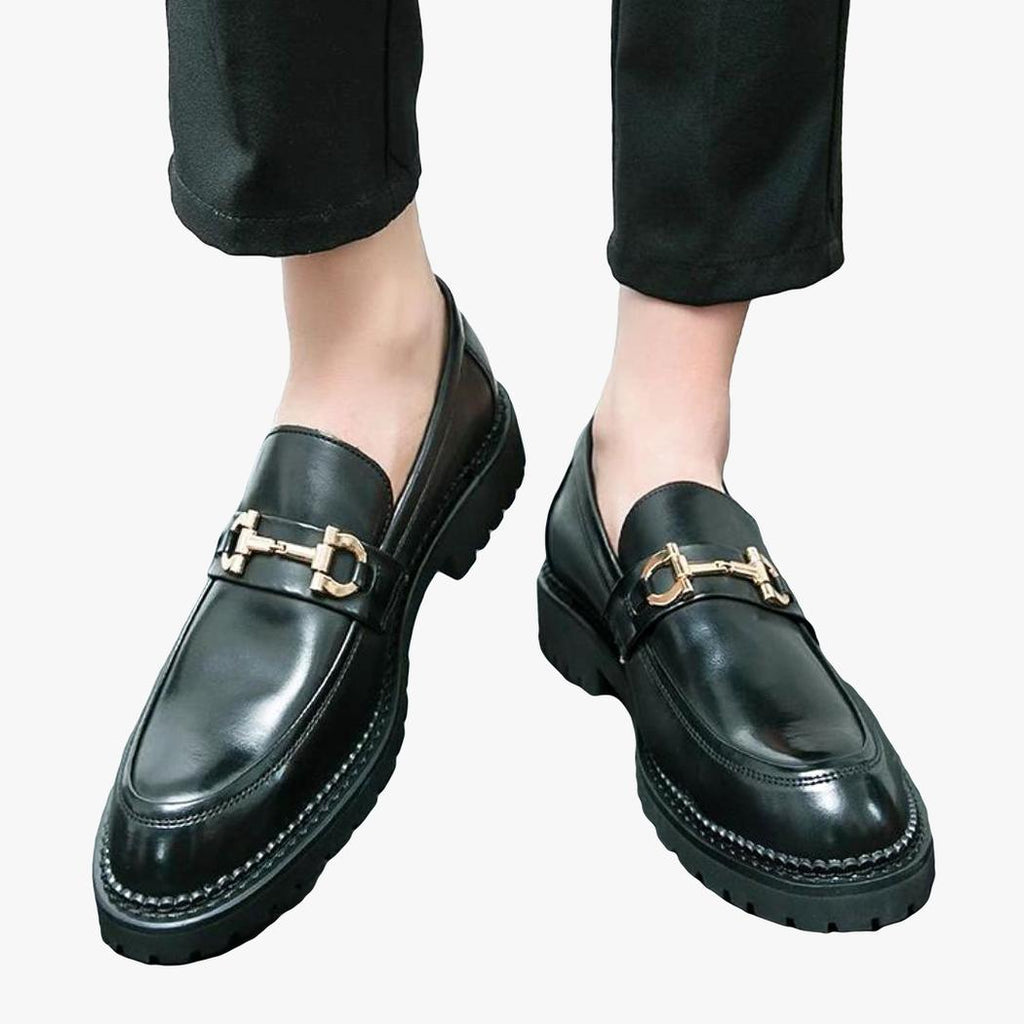 on voit les pieds d'un homme qui porte des mocassins noirs avec mors en métal en cuir véritable pour homme