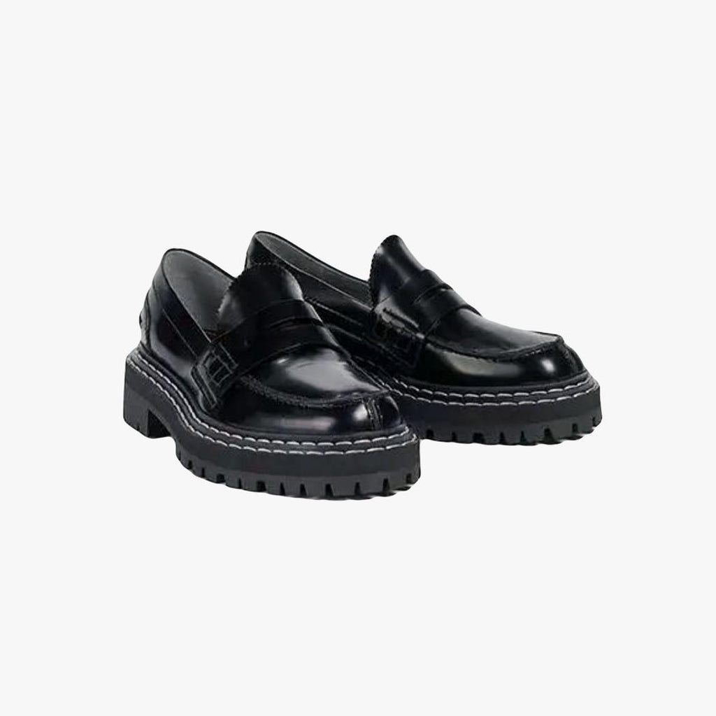 on voit sur un fond gris clair une paire de mocassins noirs à semelles épaisses pour femme en cuir véritable