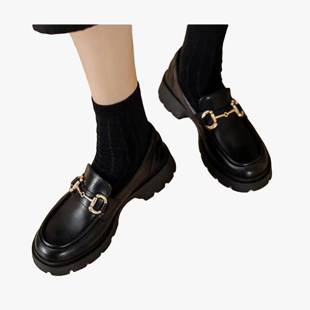 on voit les pieds d'une femme avec des chausettes noires et des mocassins noirs à talon carré et avec morsetti simple pour femme