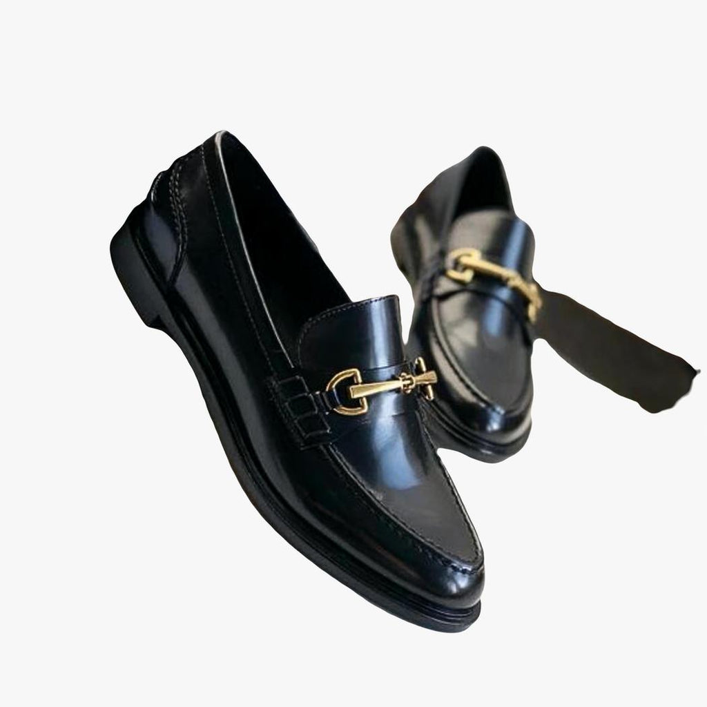 on voit sur un fond blanc une paire de mocassins noirs en cuir véritable à talon carré pour femme