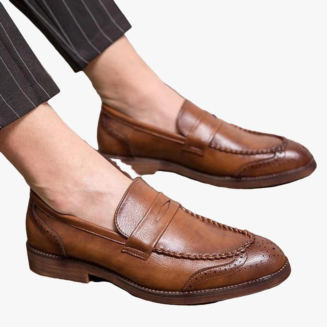 on voit un homme assis et on voit ses pieds et il porte des mocassins en cuir synthétique marron