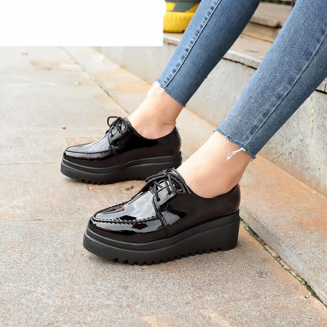 femme qui porte des mocassin compensé noir