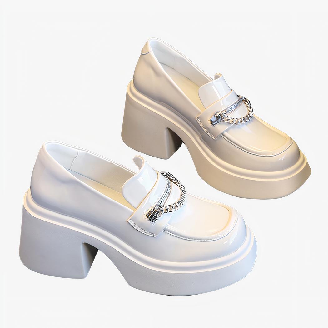 mocassin à talon compenser blanc en cuir vernis poser sur une table marron