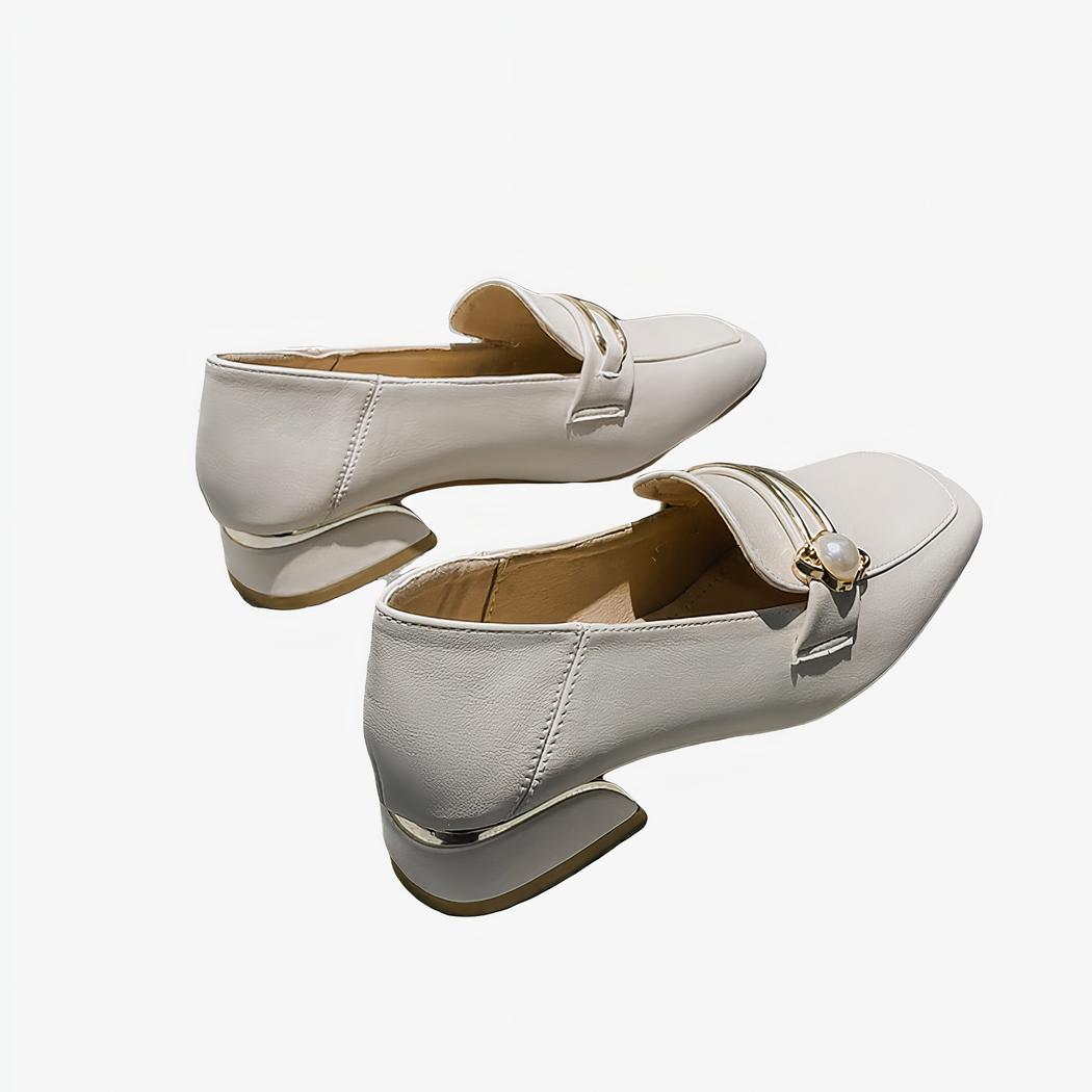 mocassin en PU blanc avec un petit talon poser sur un canapé gris