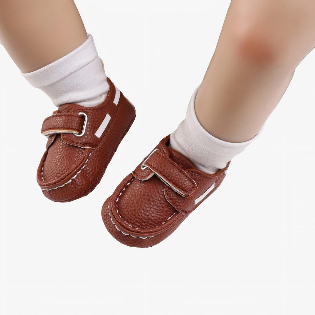 Bébé portant des chaussettes blanches et des mocassins style bateau marrons