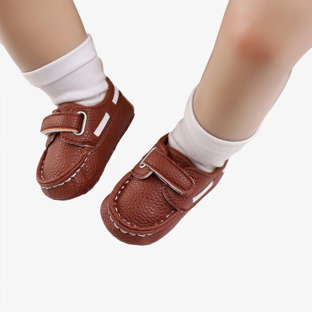 Bébé portant des chaussettes blanches et des mocassins style bateau marrons