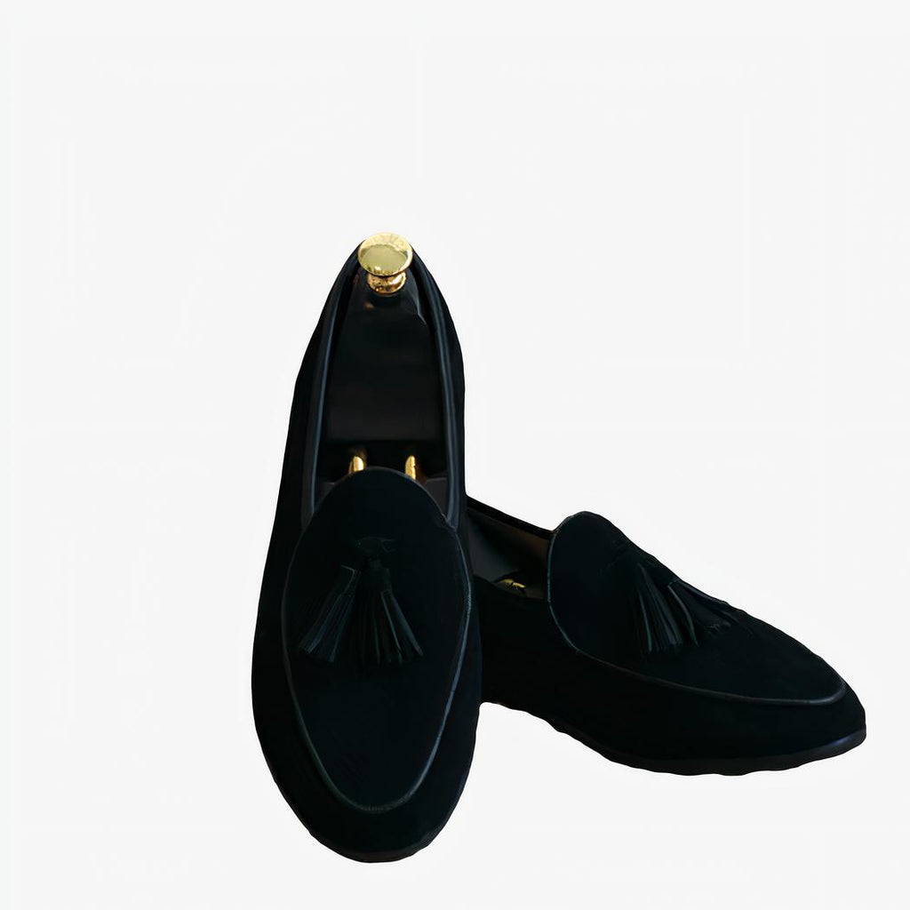 Paire de mocassins en daim pour homme de couleur bleu marine avec des glands sur le devant. À l'intérieur de la chaussure se trouve une armature en bois imitant un pied.