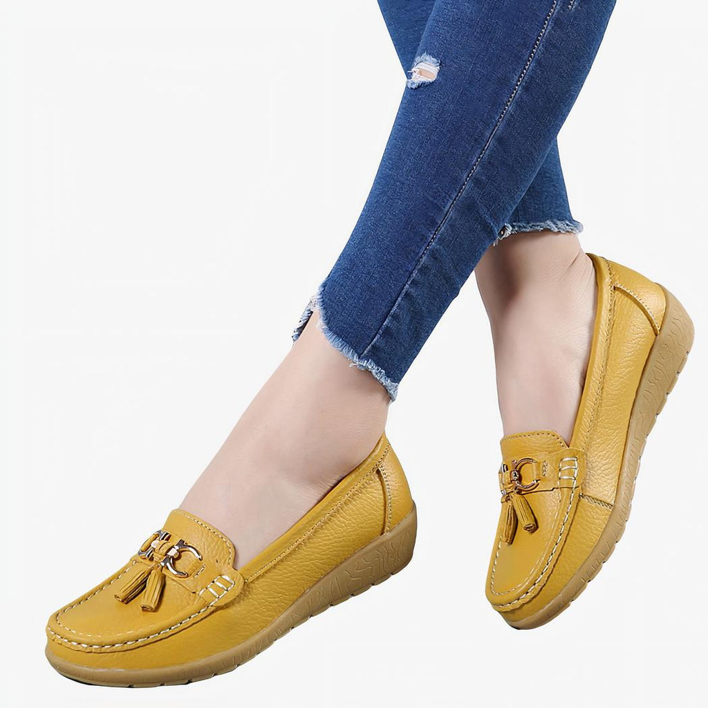 Mocassins jaunes portés par une femme dont on voit seulement les mollets.