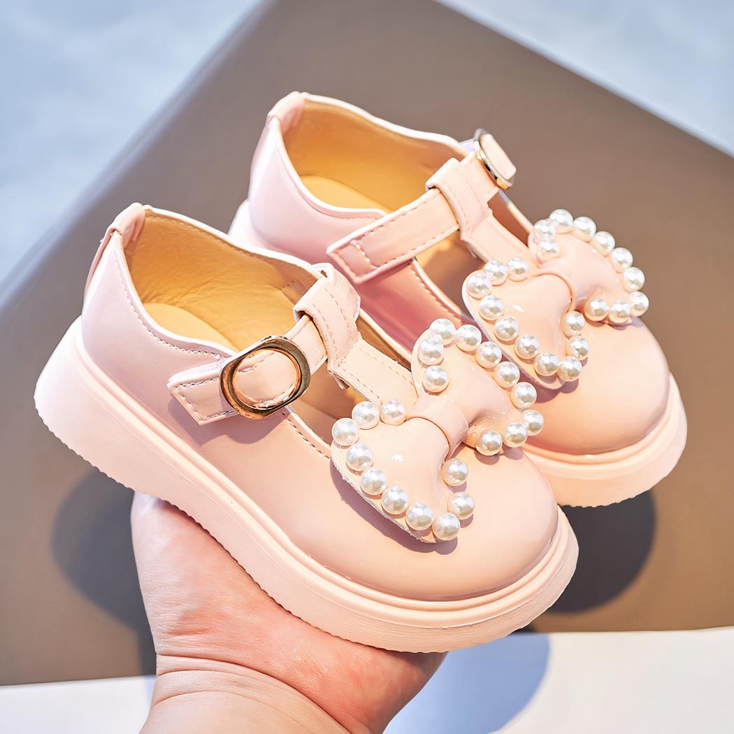 mocassin pour petite fille rose poser sur une main