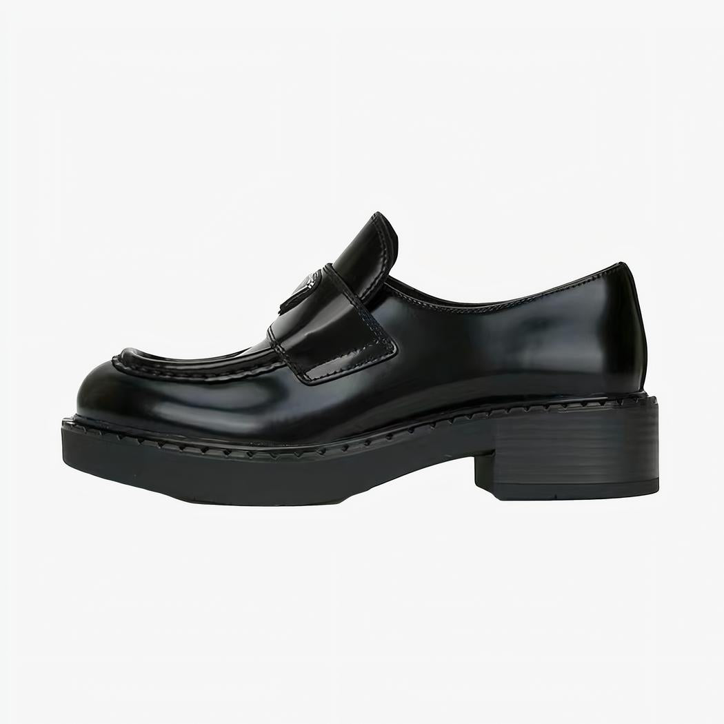 mocassin en cuir noir à petit talon mis sur un fond blanc