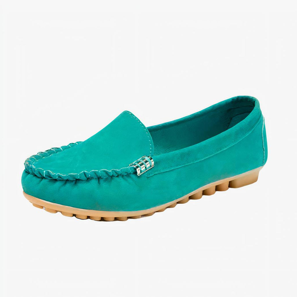 Mocassin en daim vert avec une semelle marron sur un fond blanc