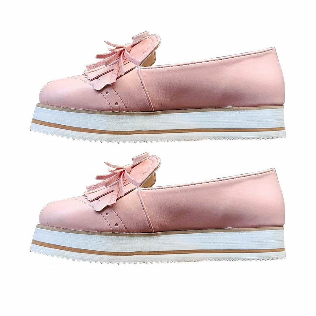 Photo d'une paire de mocassins compensés rose sur fond blanc