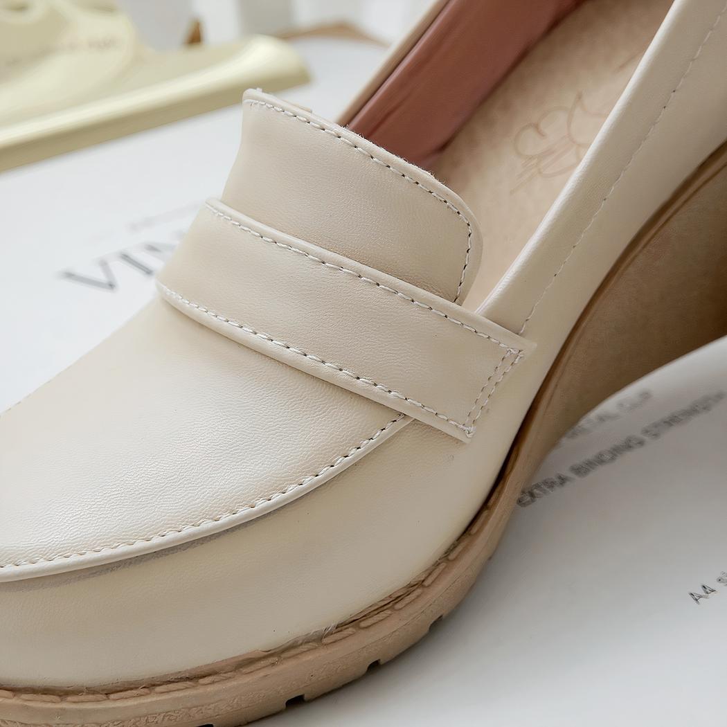 Photo d'un mocassin compensé beige sur un journal blanc