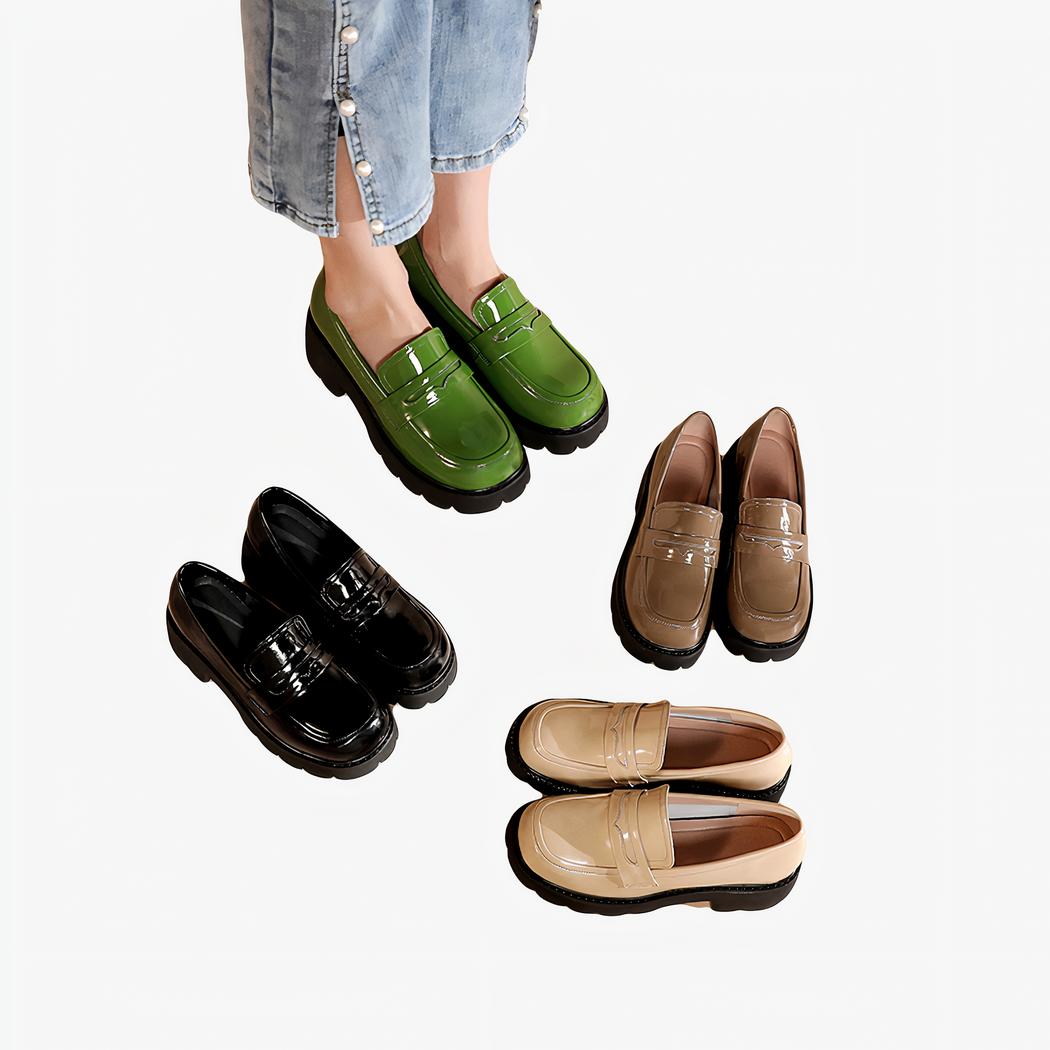 Quatre paires de mocassins en cuir vernis à semelle épaisse, simples sur un sol beige, la paire verte est aux pieds d'une femme portant un jean bleu clair, les autres paires sont beige, marron ou noir.