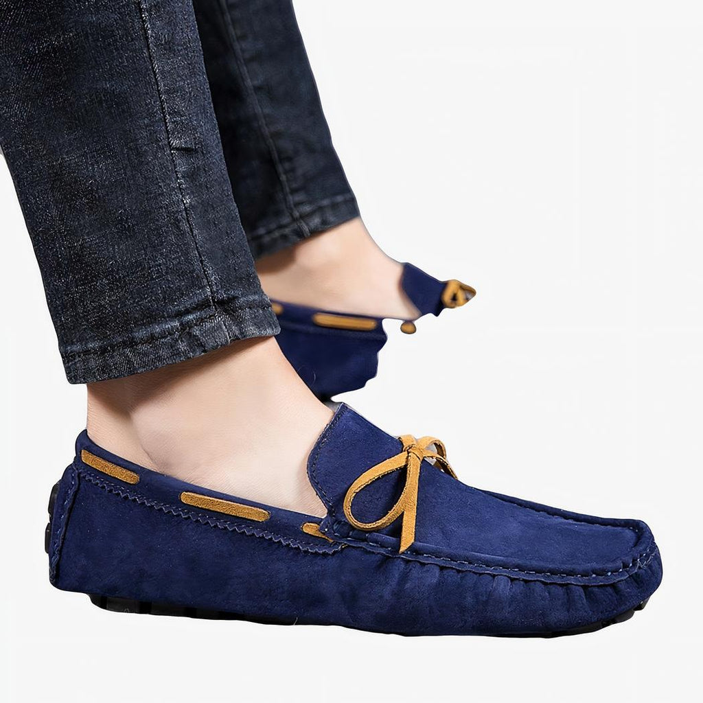 Pieds d'un homme de profil portant un jean et des mocassins bateau classiques de couleur bleue
