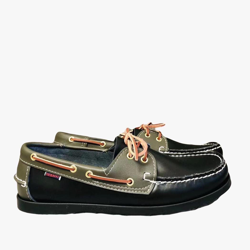 Paire de mocassins bateau noirs et kaki posés sur un sol blanc de profil