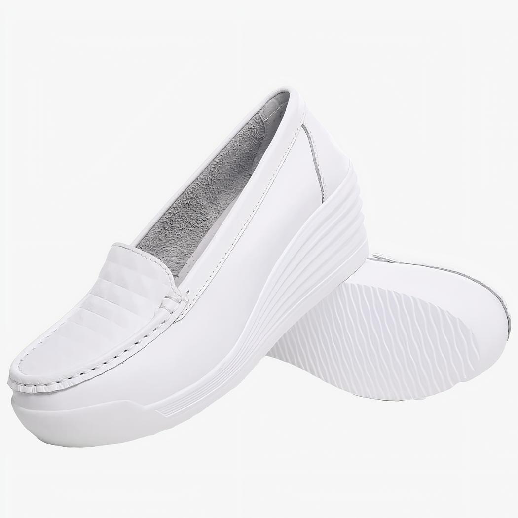 Photo d'une paire de mocassins blanche à semelle compensée sur fond blanc