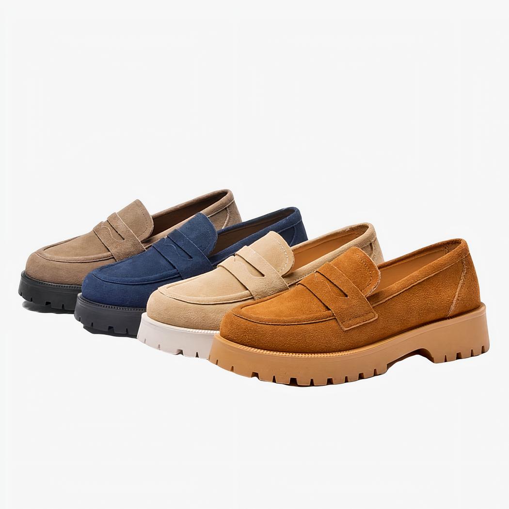 Quatre mocassins en daim simples de couleurs différentes, gris bleu beige et marron à semelle épaisse alignés sur un fond blanc.