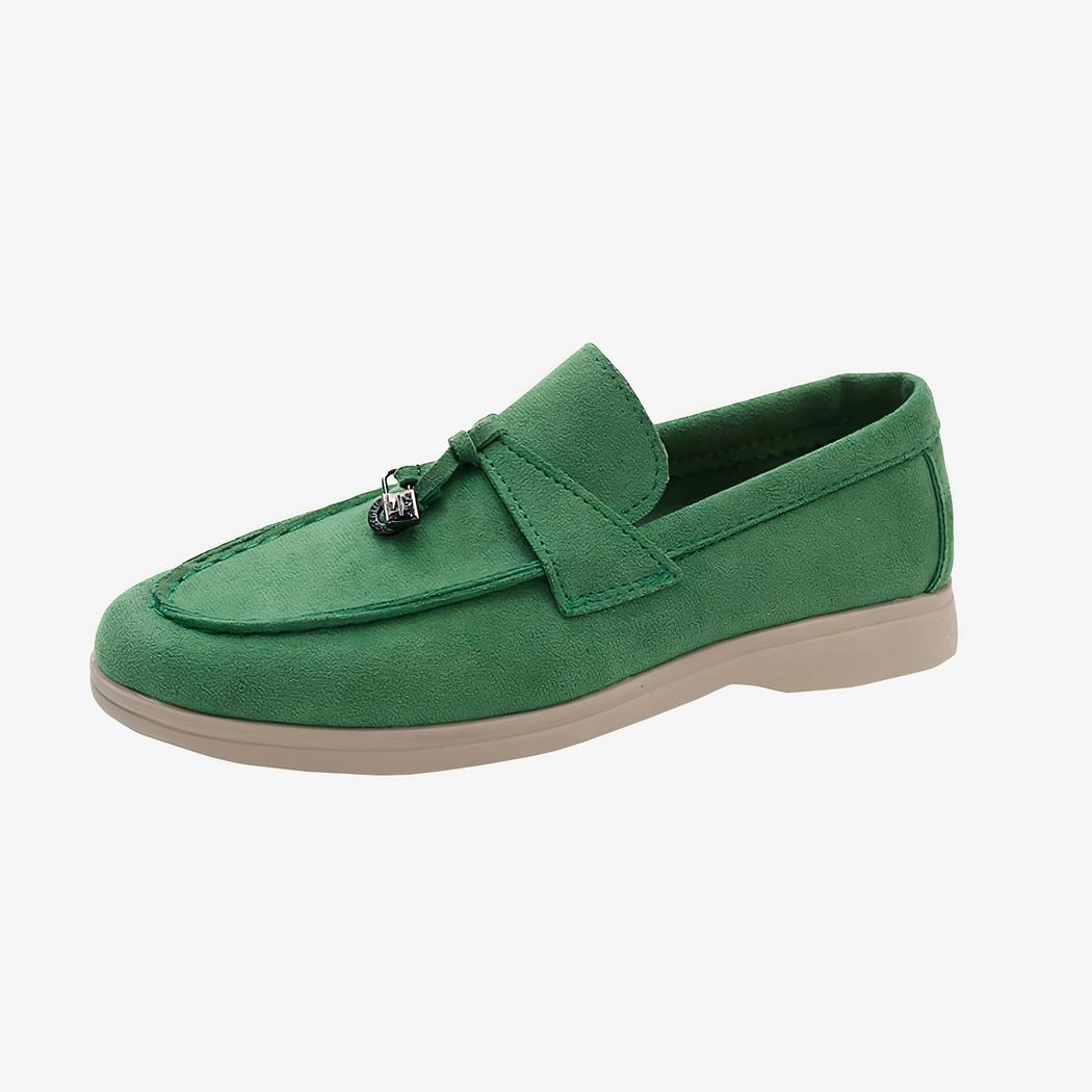 Mocassin en daim vert avec une semelle beige poser sur un fond blanc