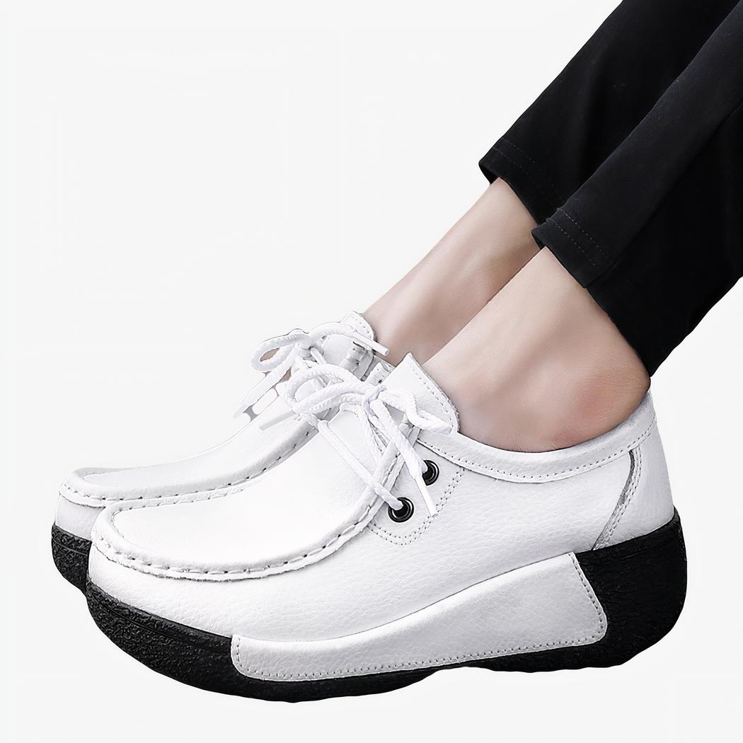 Femme de profil portant un pantalon noir et des mocassins style bateau blancs