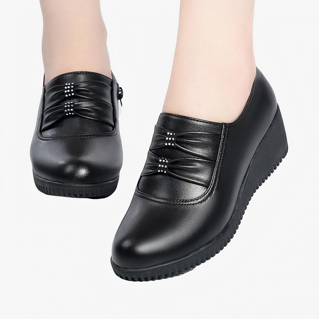 Mocassins compensés confortables effet cuir noir pour femmes avec un fond blanc