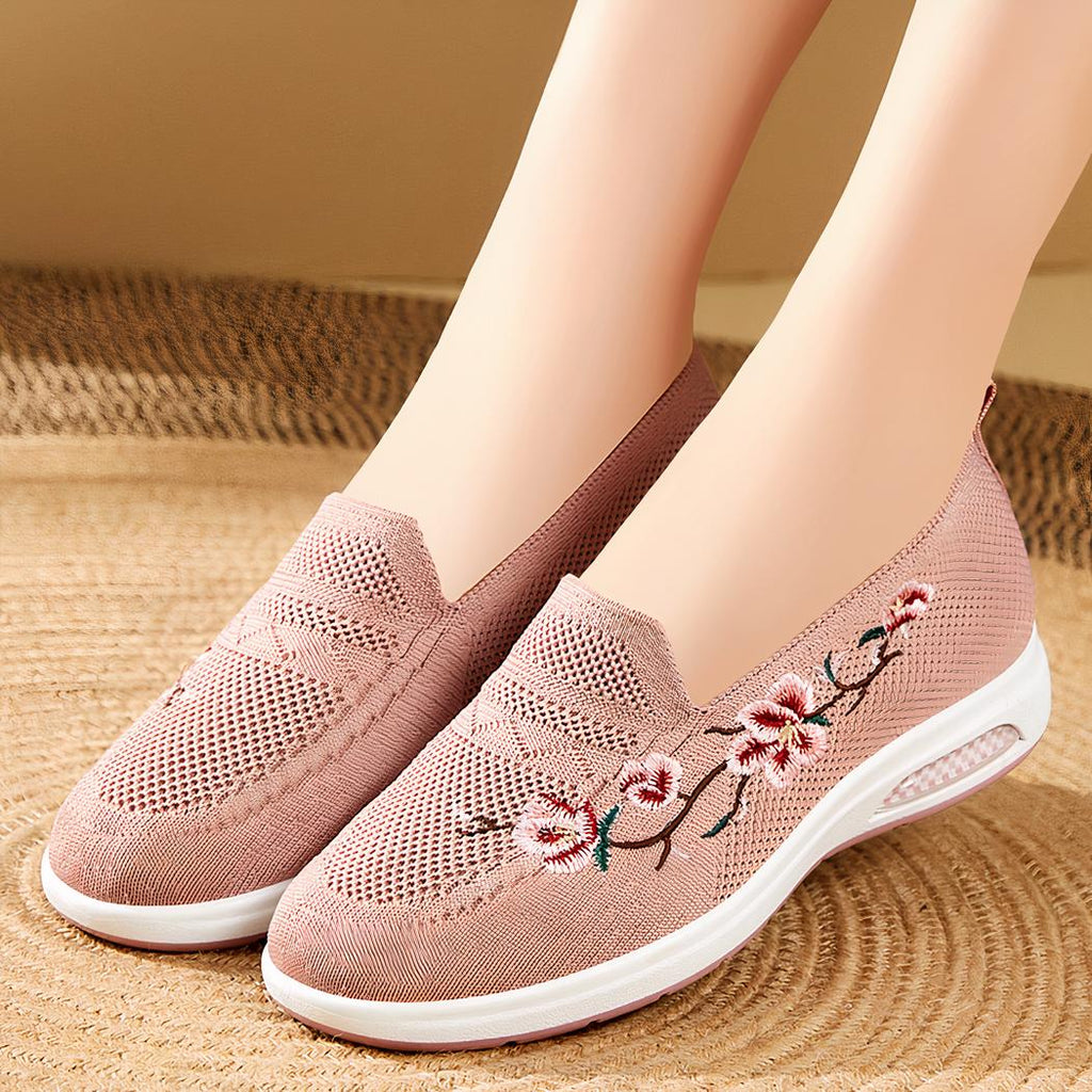 Photo d'une paire de mocassins à plateforme rose portée par une femme sur un sol beige