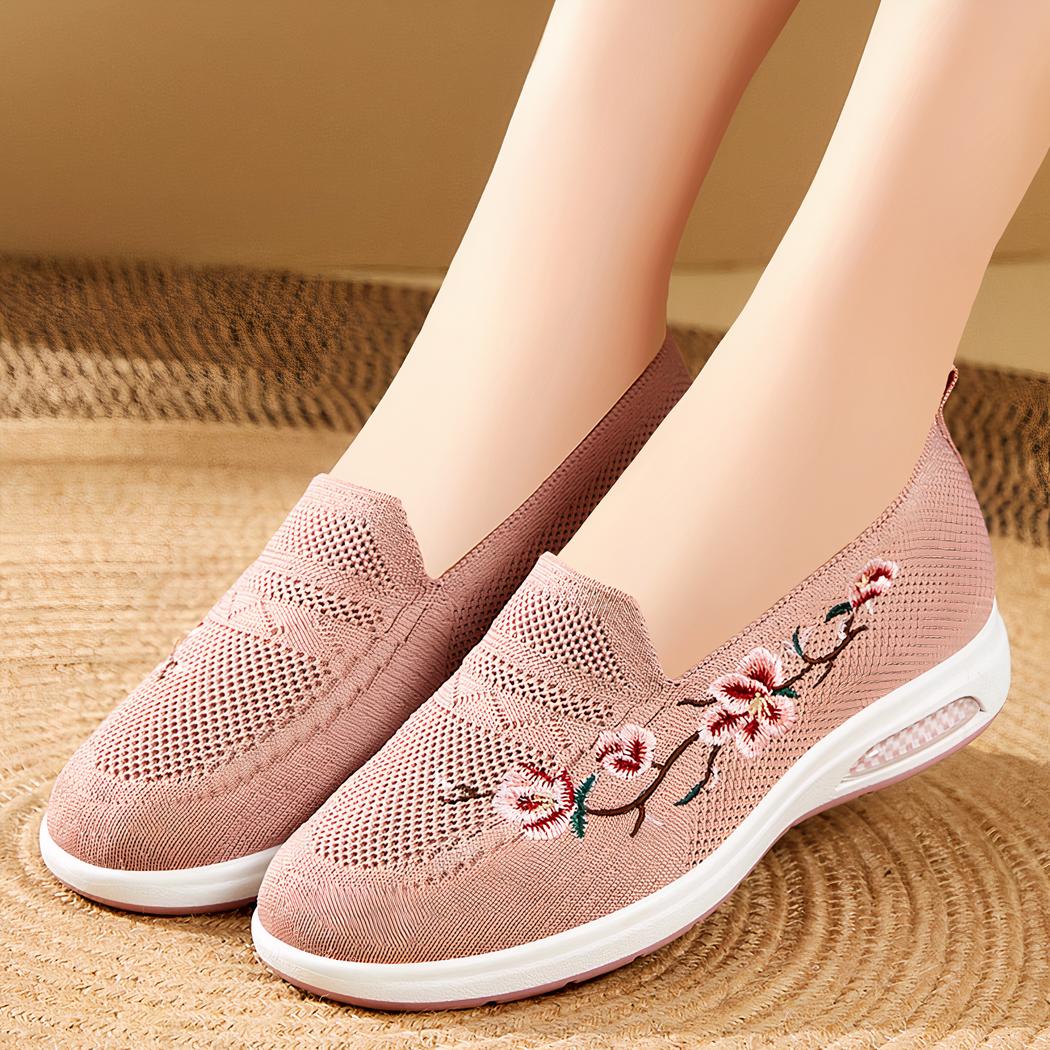Photo d'une paire de mocassins à plateforme rose portée par une femme sur un sol beige