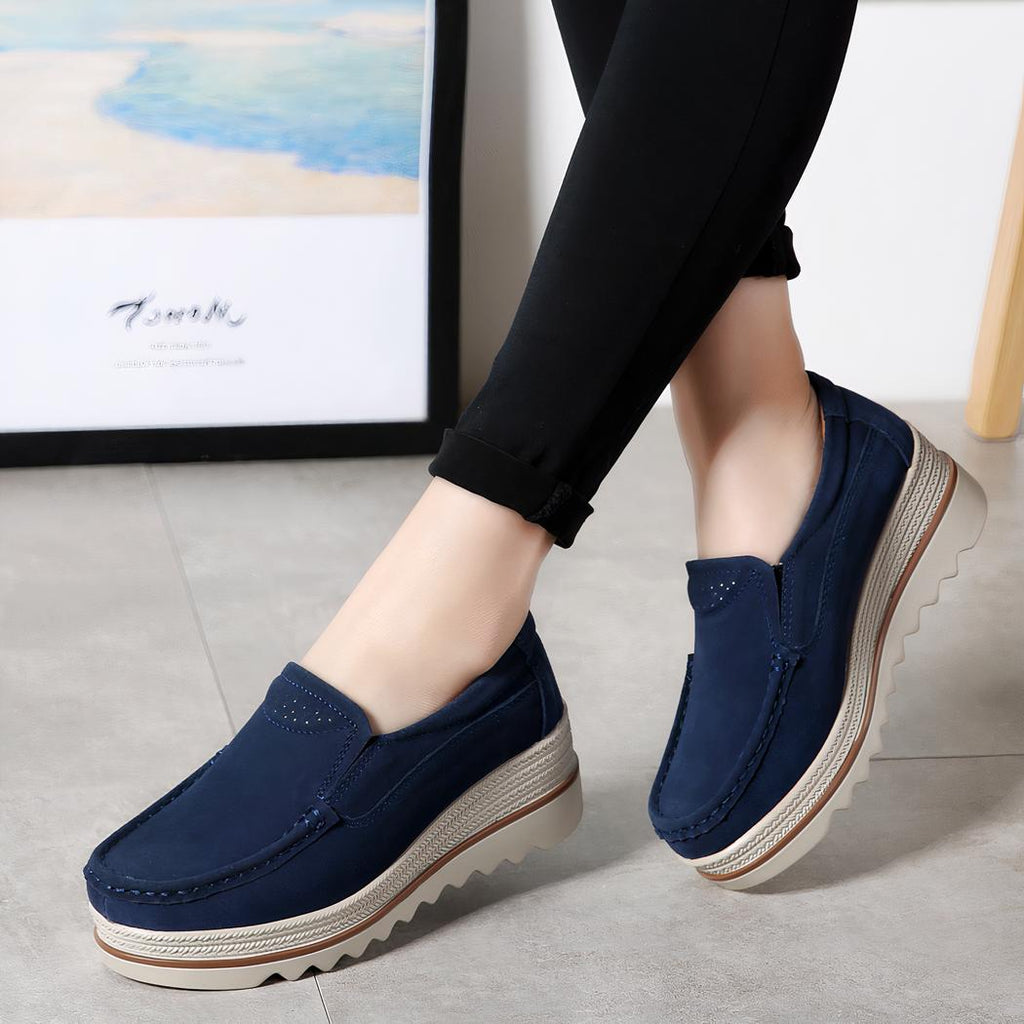 femme qui porte des mocassin compensé en daim bleu