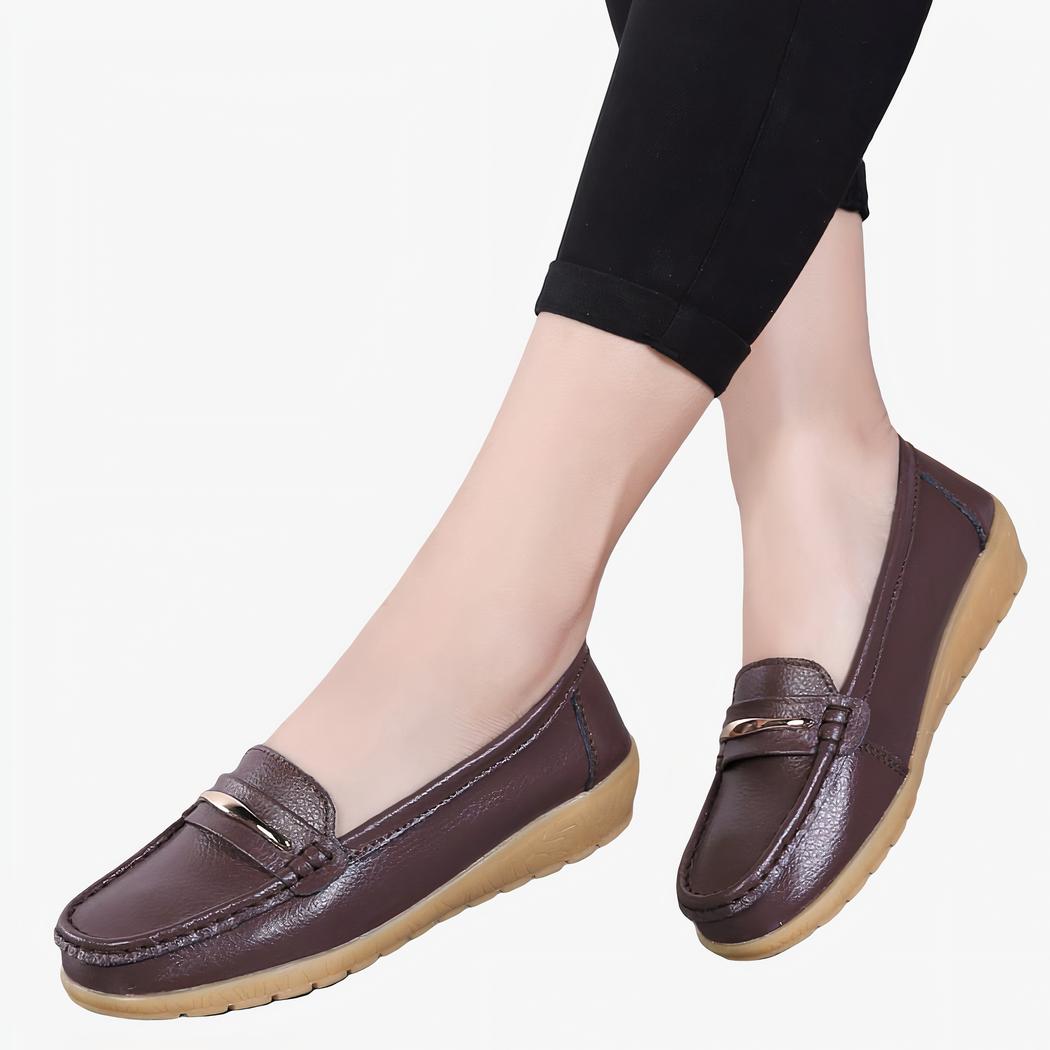 Femme portant des mocassins marrons, on voit seulement ses mollets.