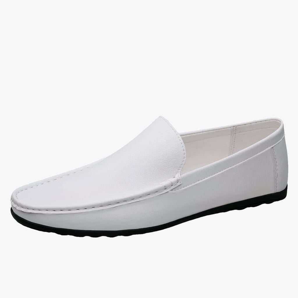 Mocassin blanc en cuir avec une semelle noire poser sur un fond blanc