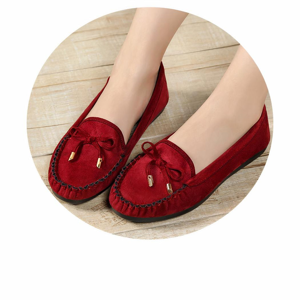 mocassin rouge en daim sur des pieds de femme