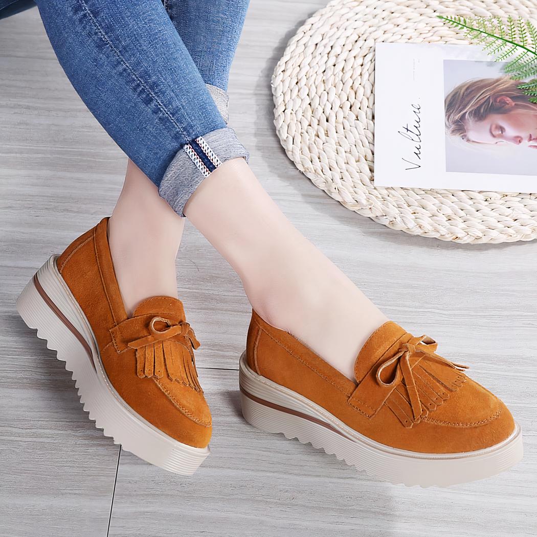 mocassin compensé à gland orange porté par une femme