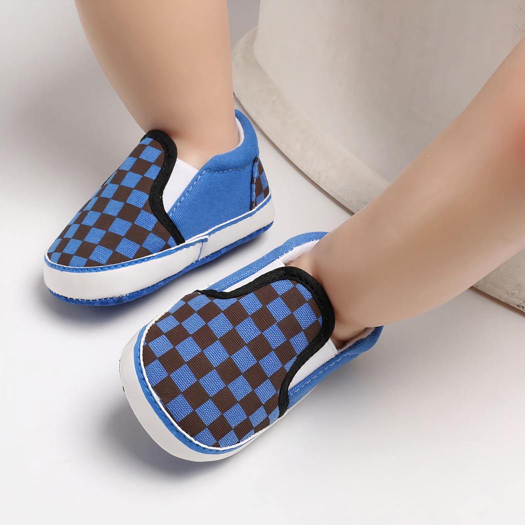 Sur fond blanc, 3 modèles de mocassins pour bébé en toile damier noir et bleu bleu, noir et blanc et gris et noir