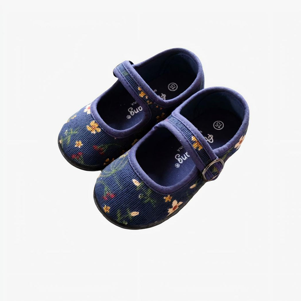 mocassin bleu en velours côtelé pour enfant poser sur un mur gris